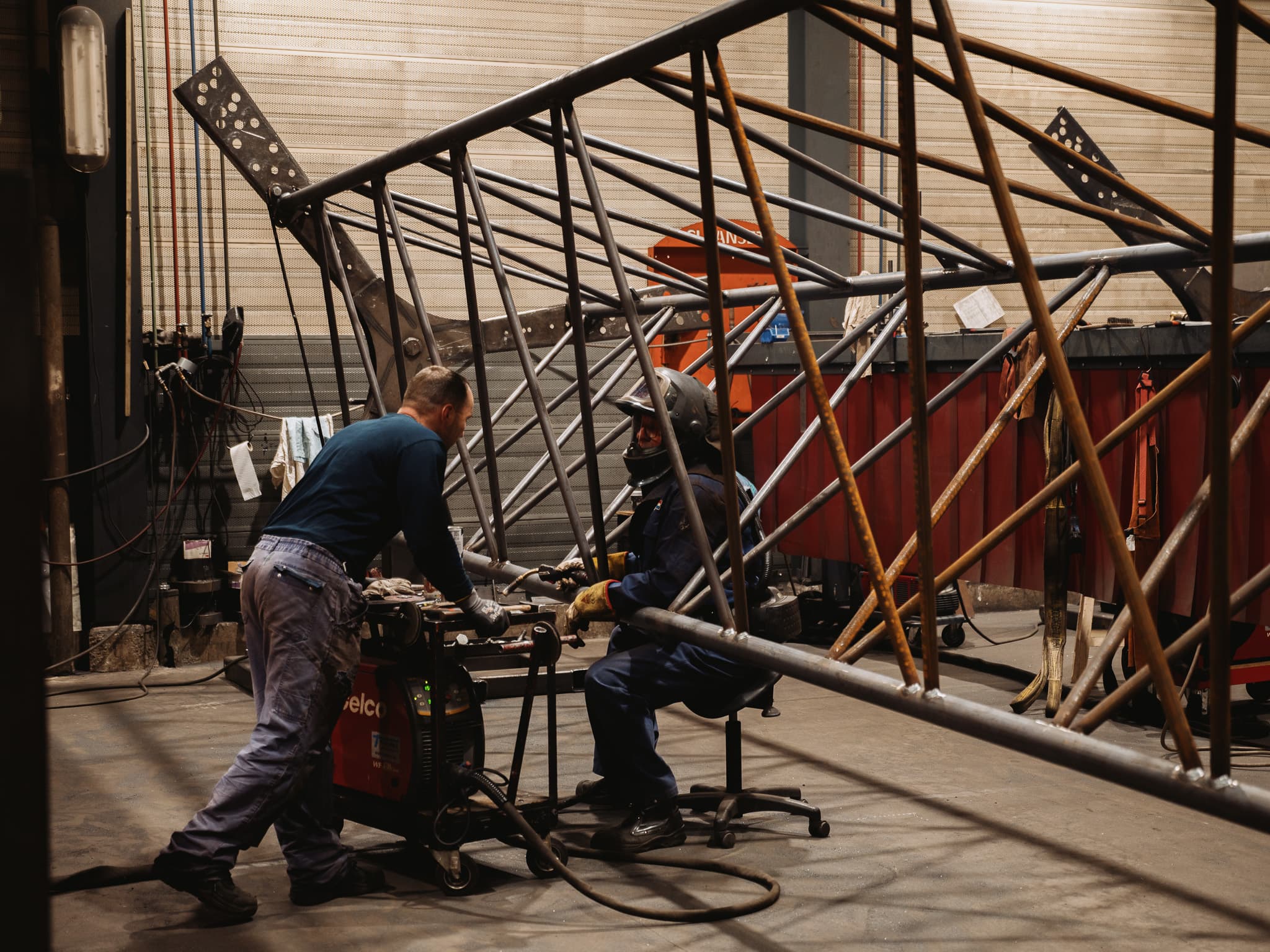 Twee lassers werken samen aan stalen vakwerkconstructie in de Hanab-productiehal