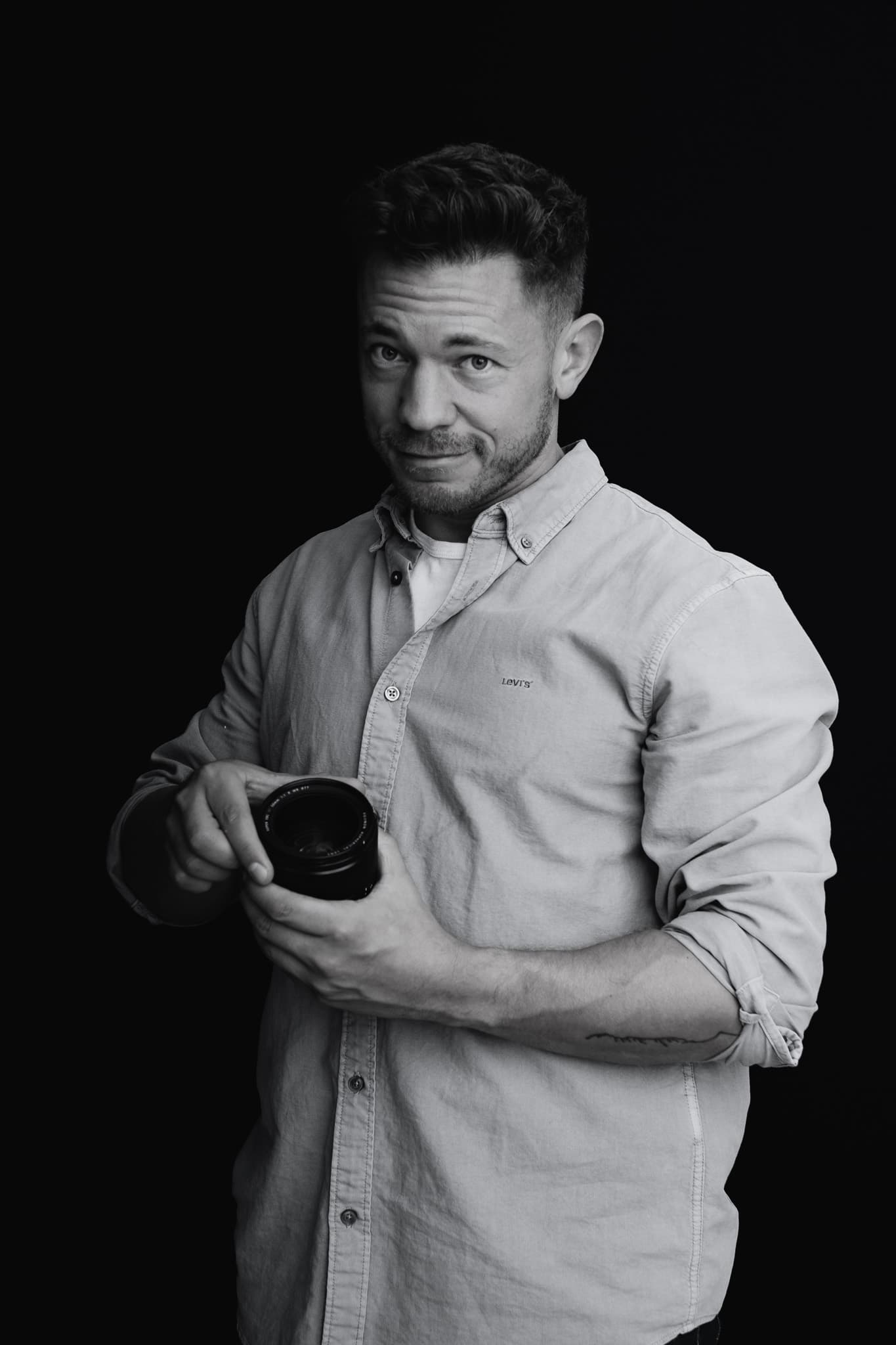 Jeffrey Roos houdt cameralens vast — zakelijke portretfotograaf Utrecht