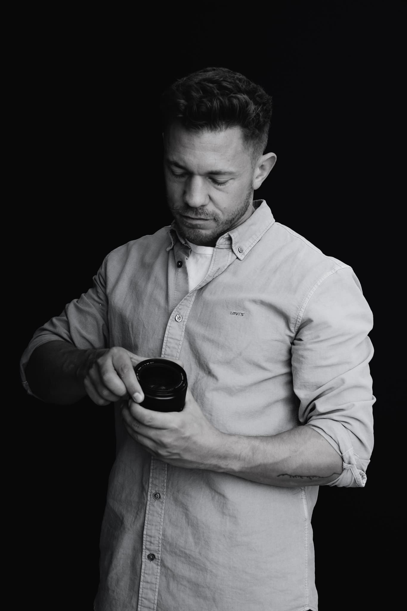 Jeffrey Roos bekijkt cameralens — premium fotograaf voor branding en corporate