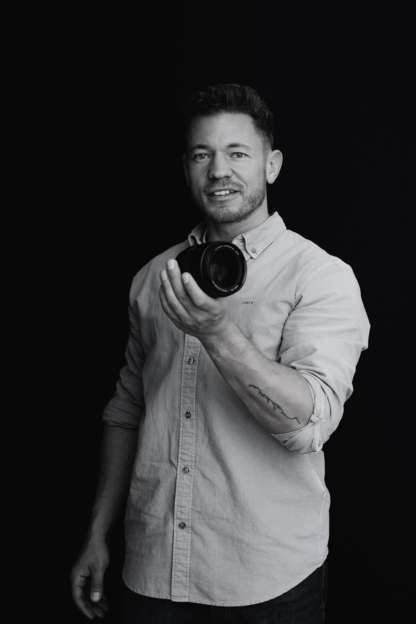 Jeffrey Roos toont cameralens — professionele headshot fotograaf Nederland