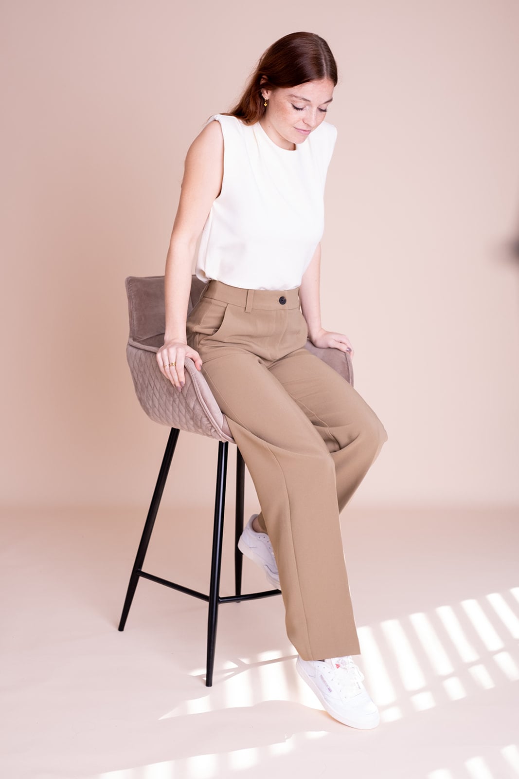 Brunette vrouw in wit shirt zit op stoel - professionele personal branding Utrecht