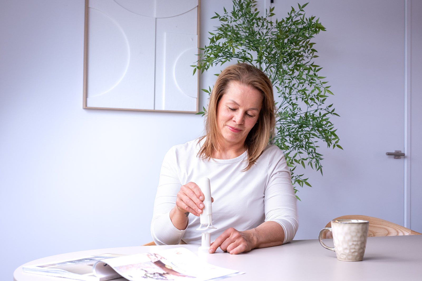 Blonde vrouw brengt handcrème aan tijdens magazine lezen - brand storytelling fotografie