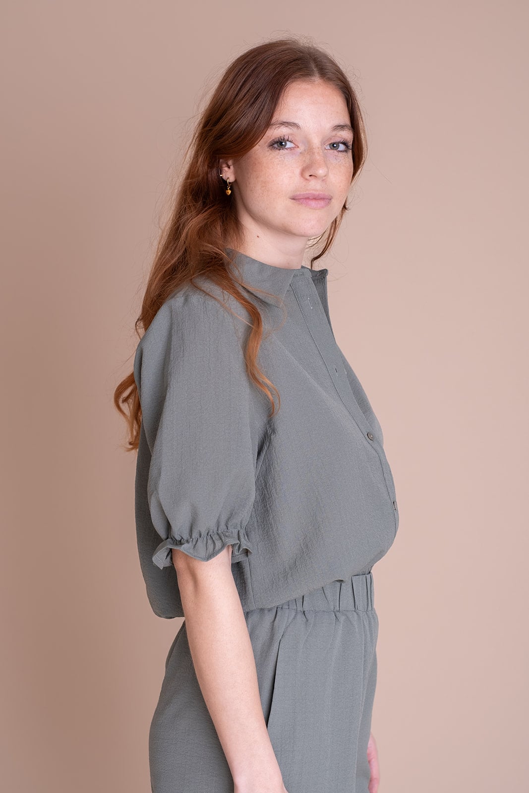 Jonge vrouw in grijze blouse kijkt zelfverzekerd - personal branding portret fotograaf Utrecht