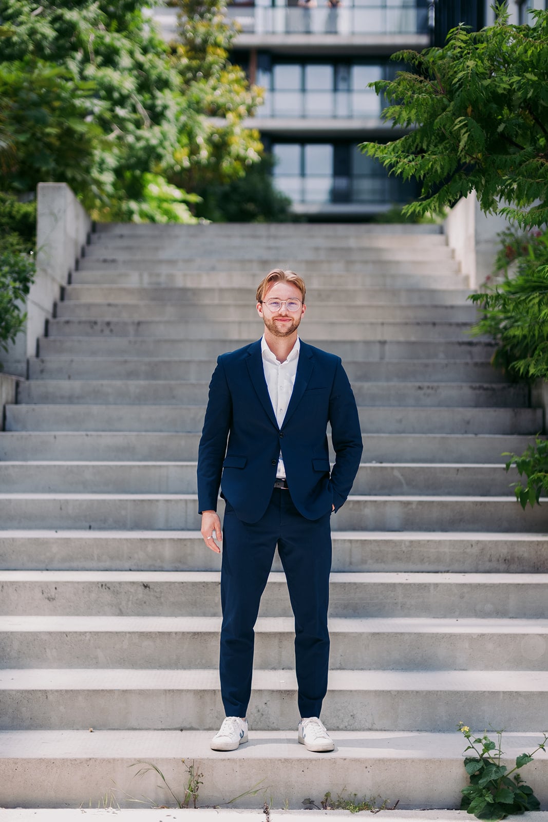 Zakelijk portret man in donkerblauw pak op trap - professionele headshot fotograaf Utrecht