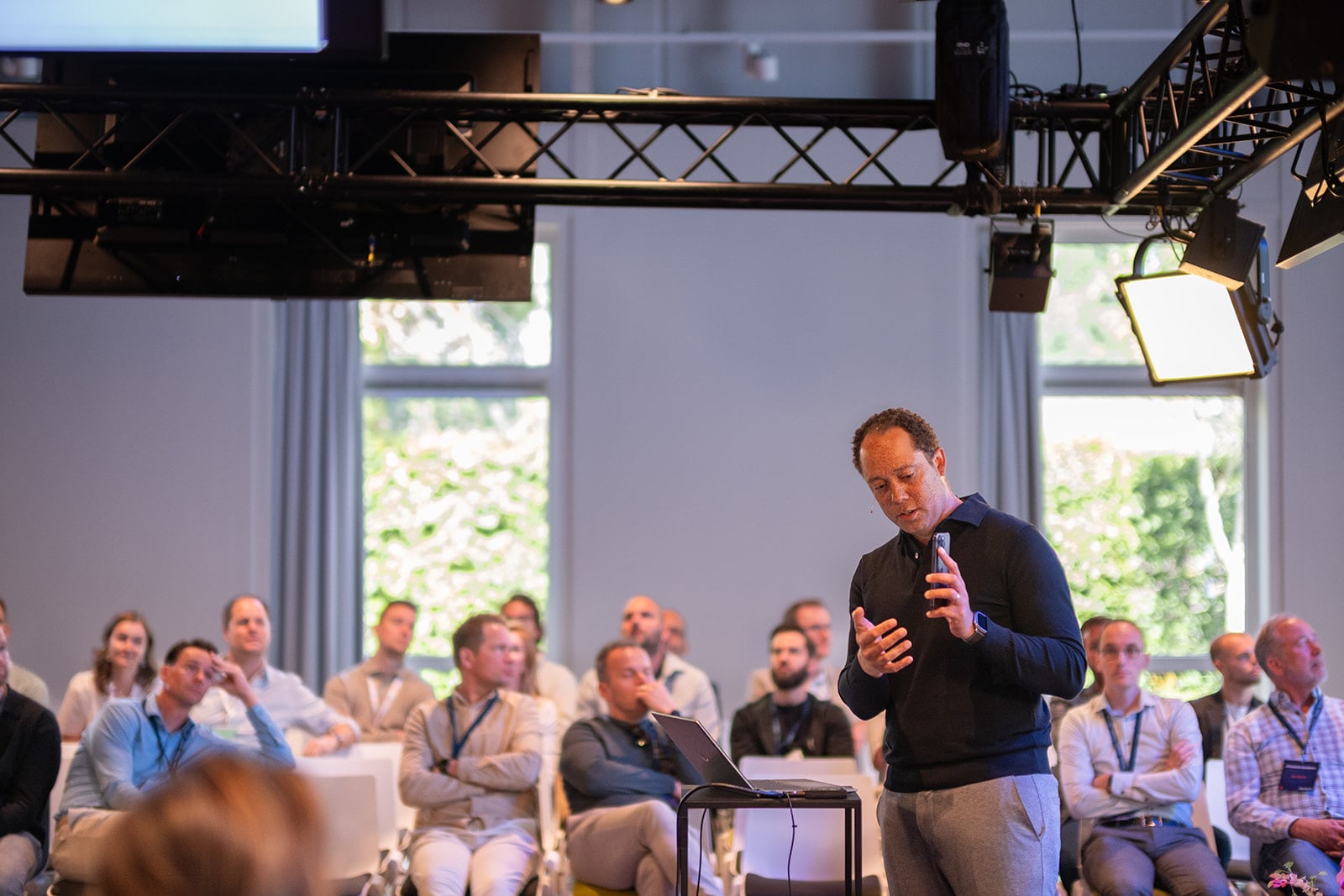 Business spreker presenteert voor publiek in moderne evenement zaal met professionele belichting