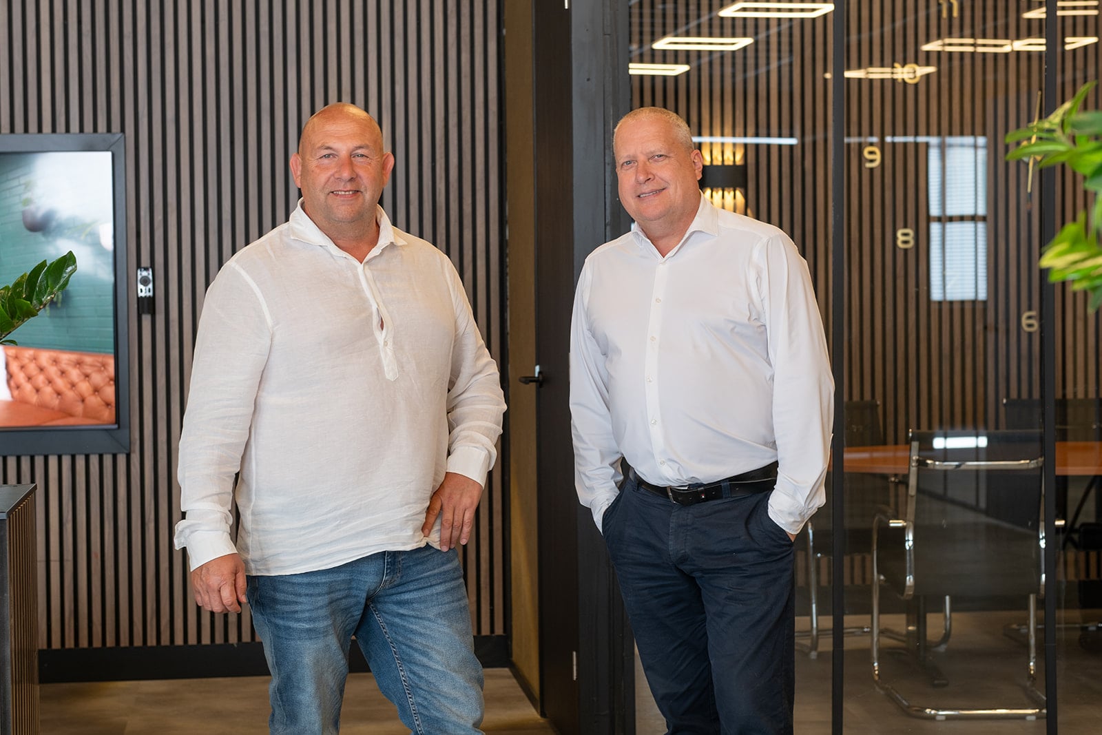 Twee directeuren poseren in moderne kantooromgeving zakelijke portretfotografie