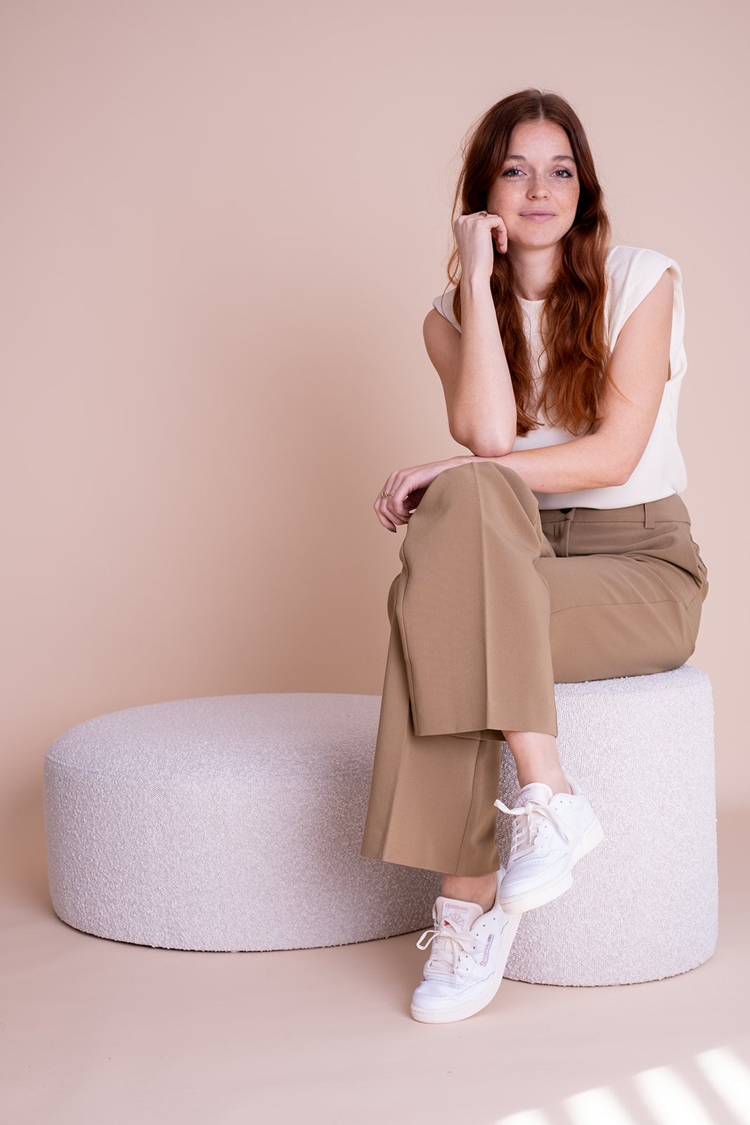 Vrouw in beige broek zit ontspannen - casual branding fotografie lifestyle Utrecht