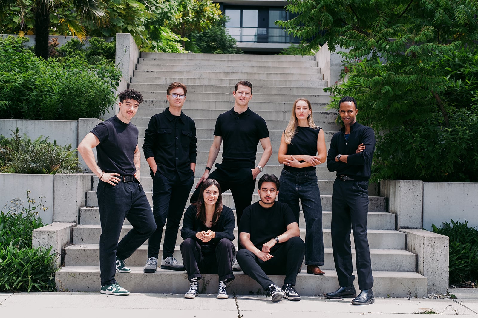 Groepsportret van zeven professionals op betonnen trap - teamfotografie Utrecht door Jeffrey Roos