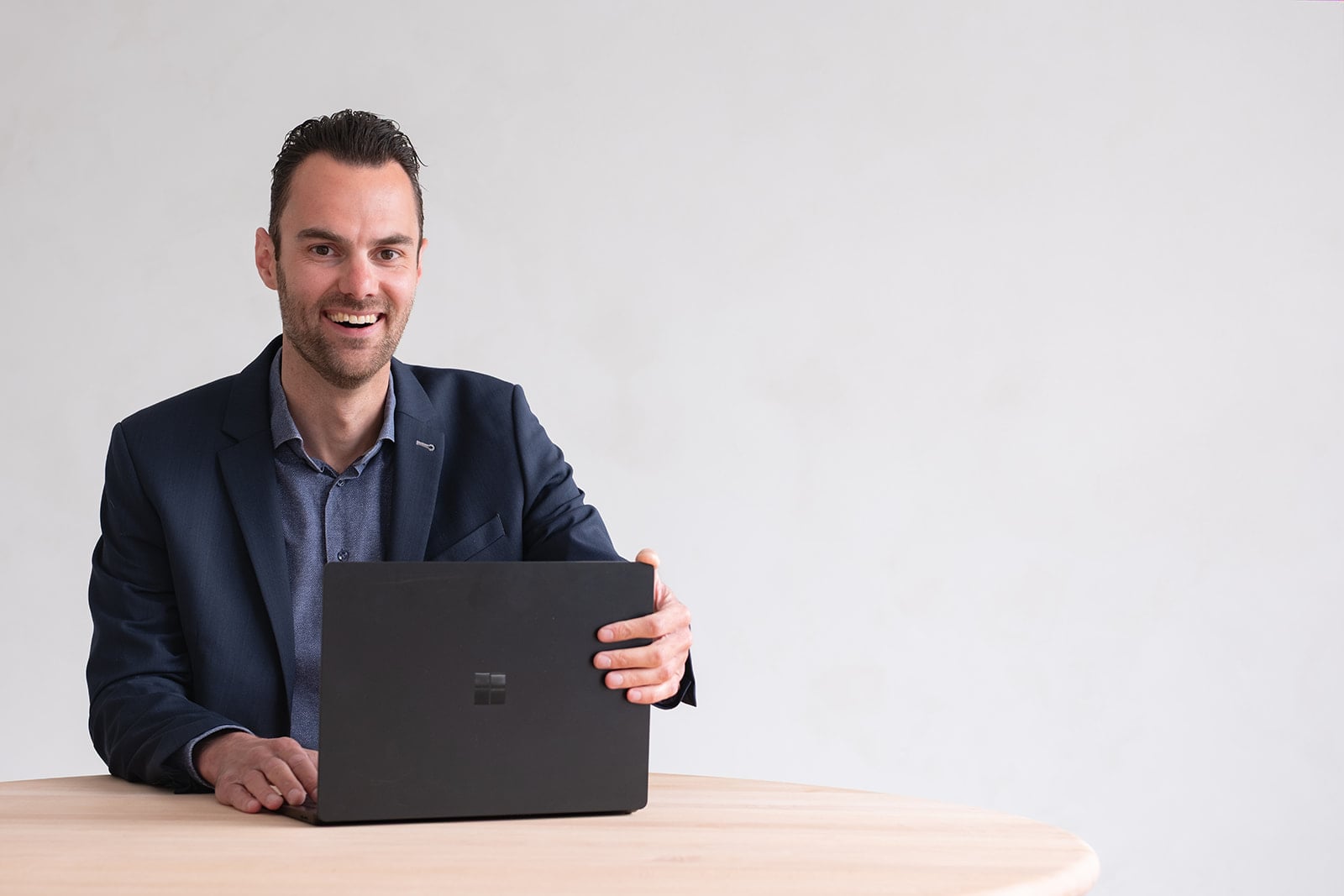 Professional in pak achter laptop op houten bureau bedrijfsfotografie