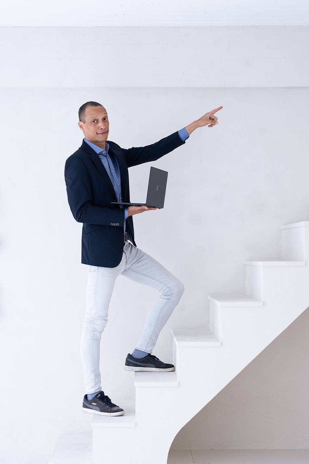 Zakelijke man wijst met laptop in hand corporate fotograaf Utrecht