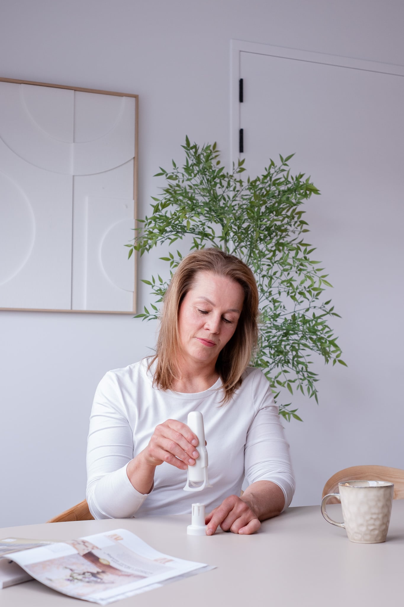 Vrouw concentreert zich op Upatch applicatie in scandinavisch gestyleerde woonkamer setting