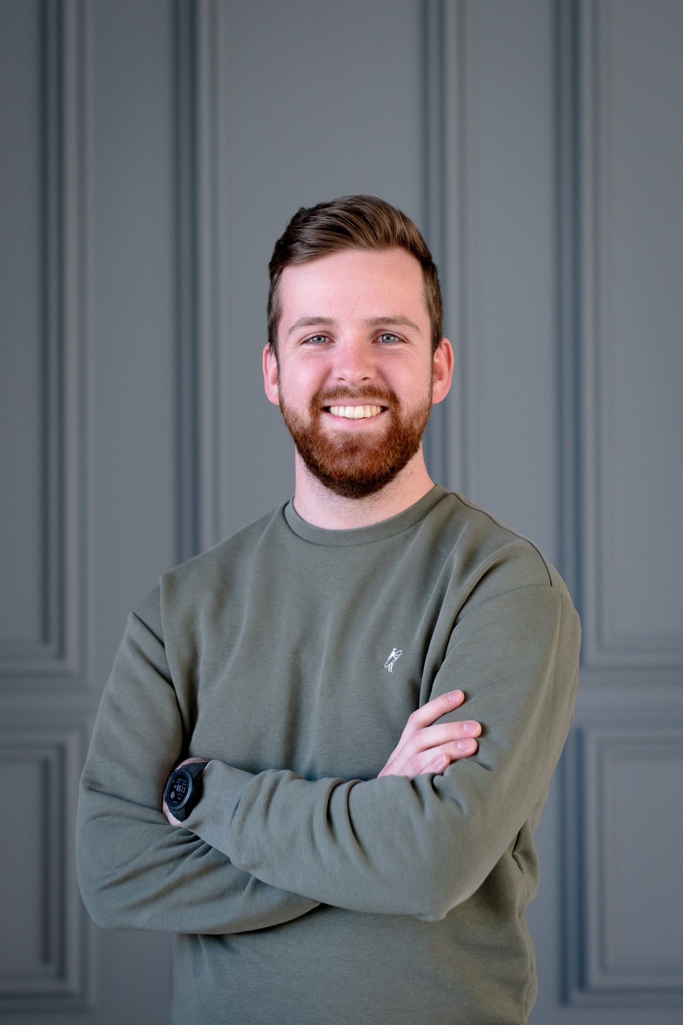Jonge bebaarde man met gekruiste armen lacht vriendelijk zakelijk portret fotograaf Utrecht
