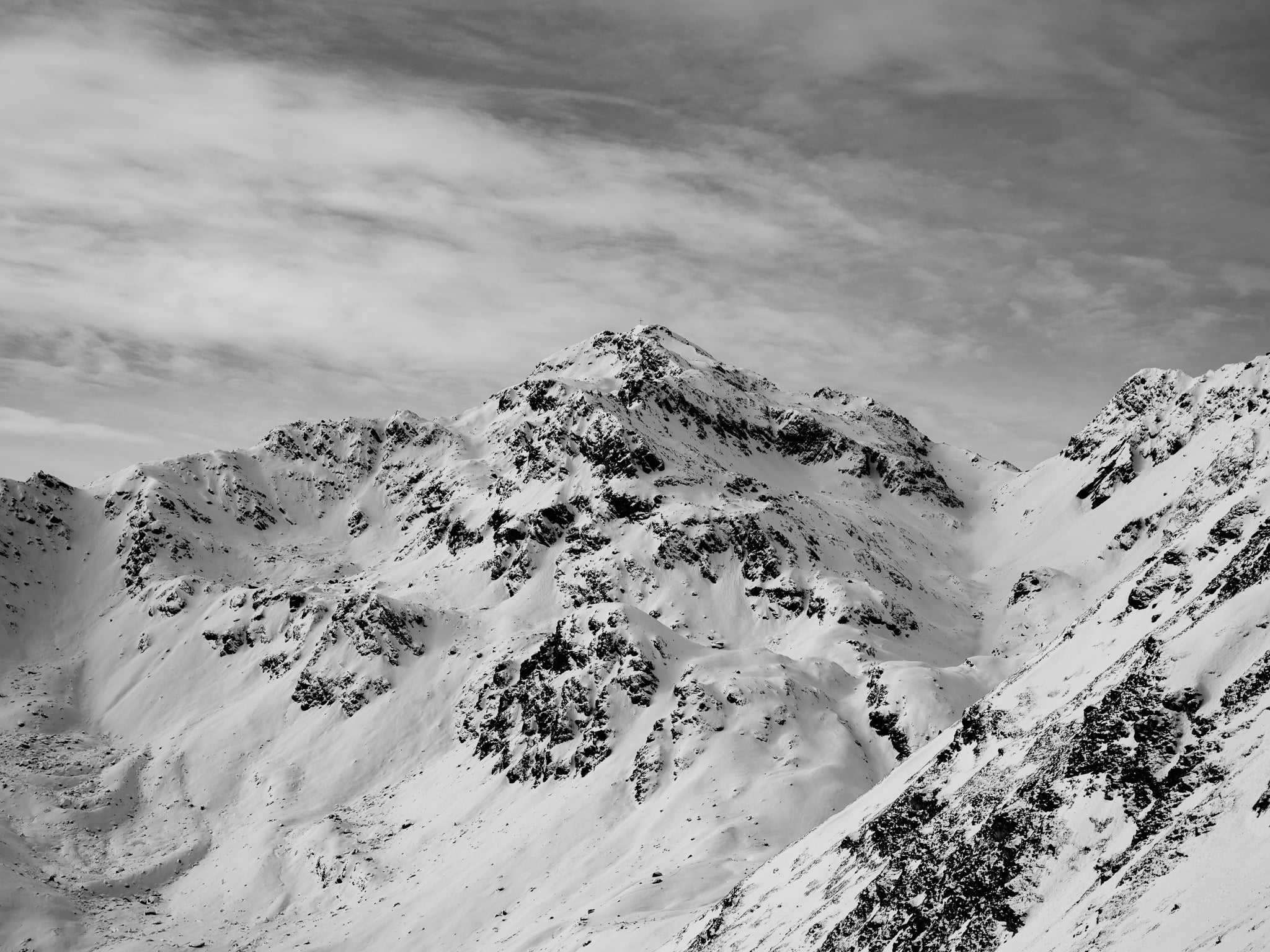 Dramatische zwart-wit bergkam met sneeuw en wolkenformaties - Alpine landschapsfotografie