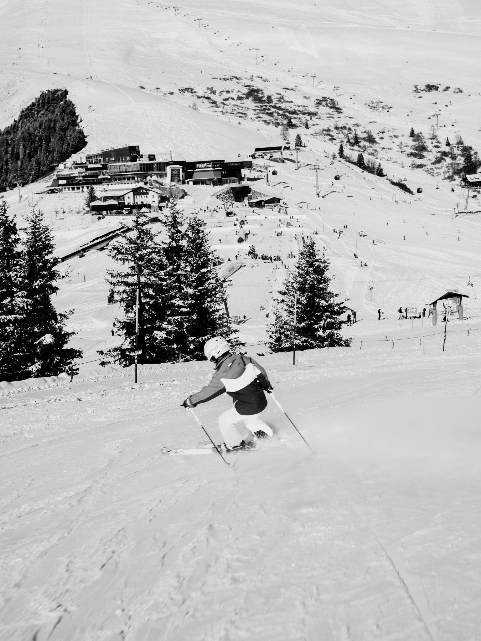 Skiër carvet door poedersneeuw met bergstation achtergrond - Alpine skigebied actie