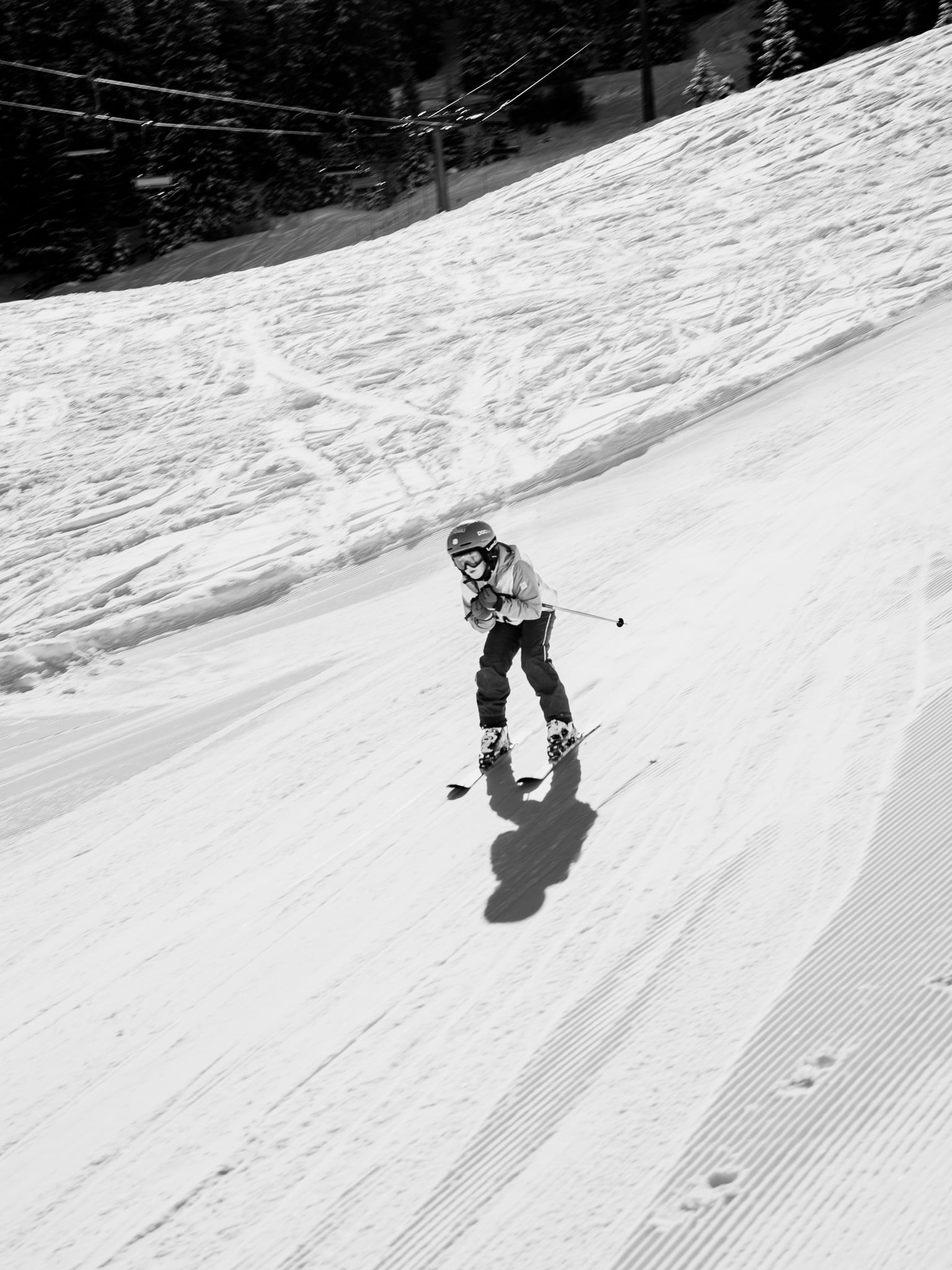 Kind skiënd met helm op zonnige piste - jeugd wintersport fotografie