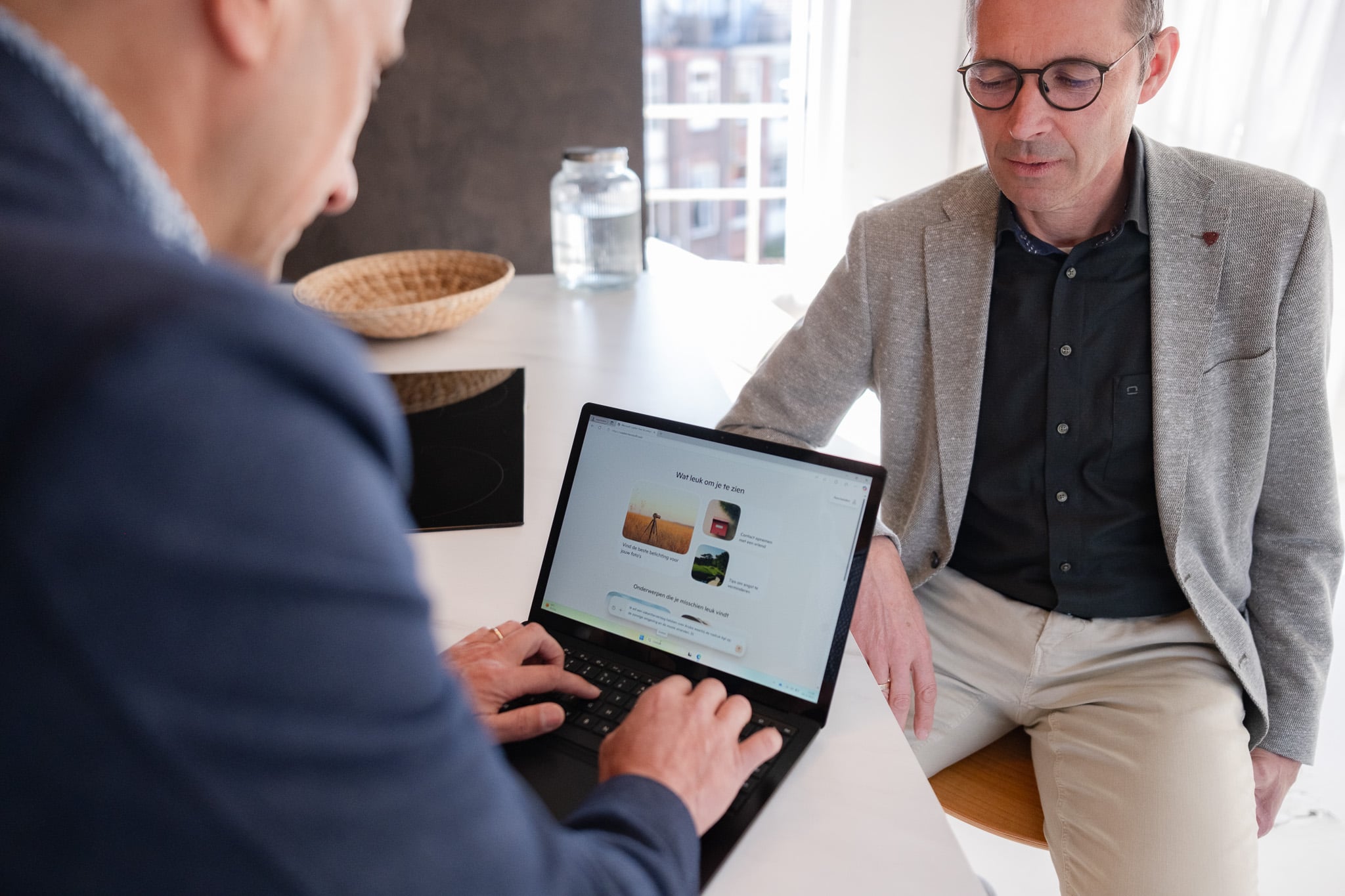 Twee collega's bespreken laptop presentatie aan vergadertafel zakelijke fotografie Rotterdam
