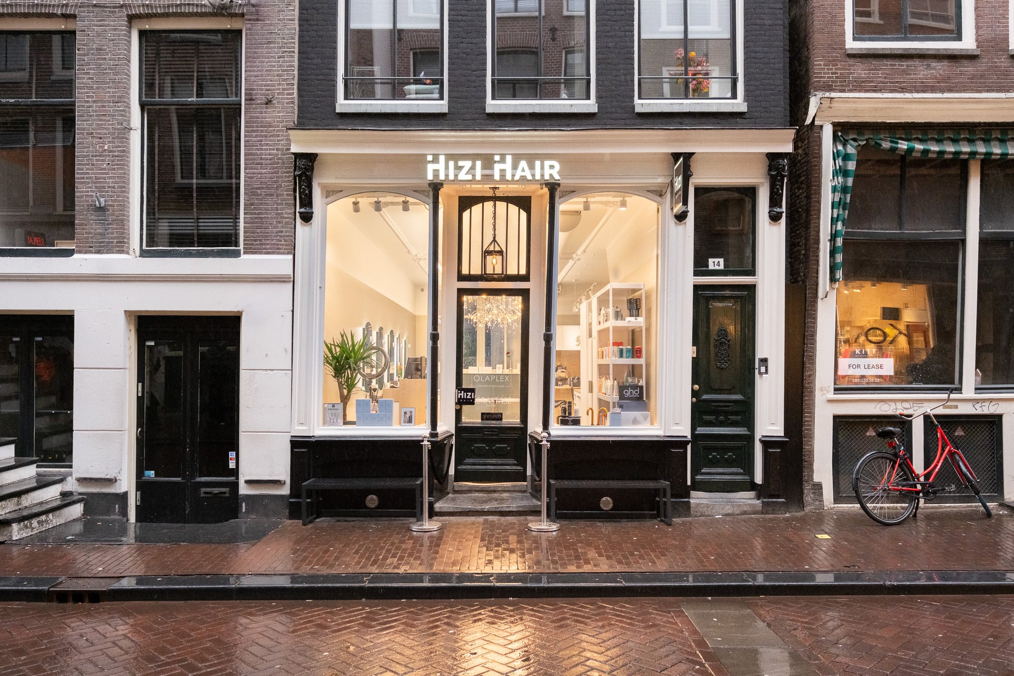 Historische kapsalon Hizi Hair pand met grote etalageruiten en rode fiets, buitenfoto bedrijf Amsterdam