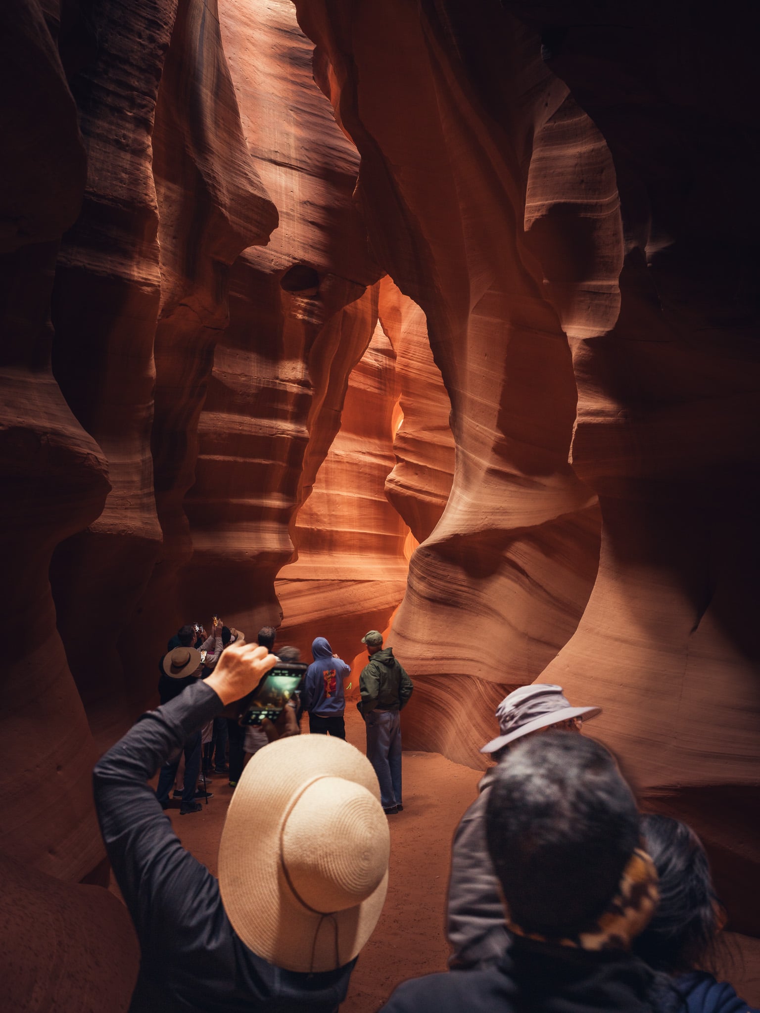 Toeristen fotograferen de golvende rode zandsteenwanden binnen in Antelope Canyon