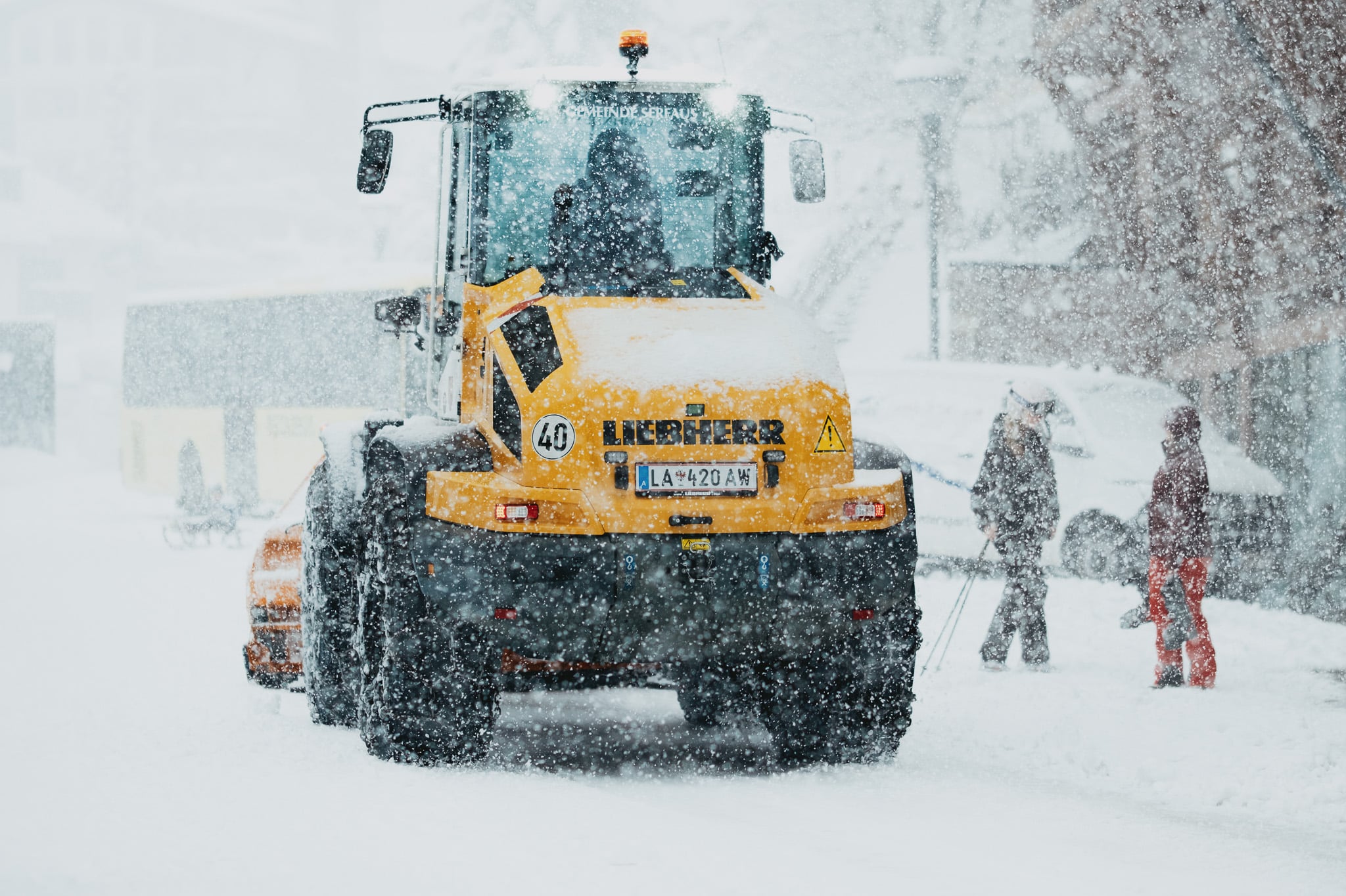 Gele Liebherr pistenkat in sneeuwstorm - professionele skiterrein machines