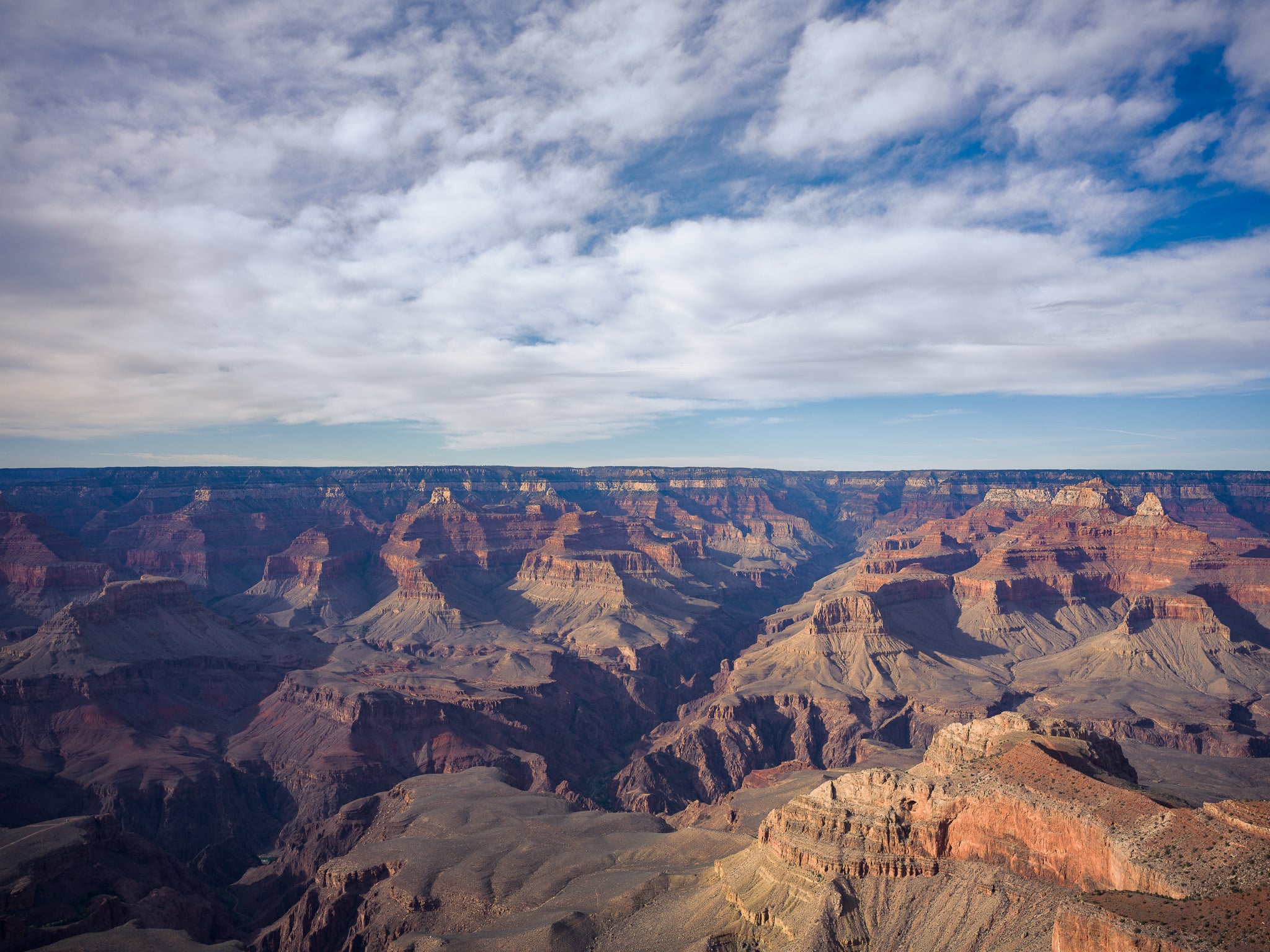 Panoramisch landschap van de Grand Canyon met roestrode canyonwanden onder bewolkte lucht