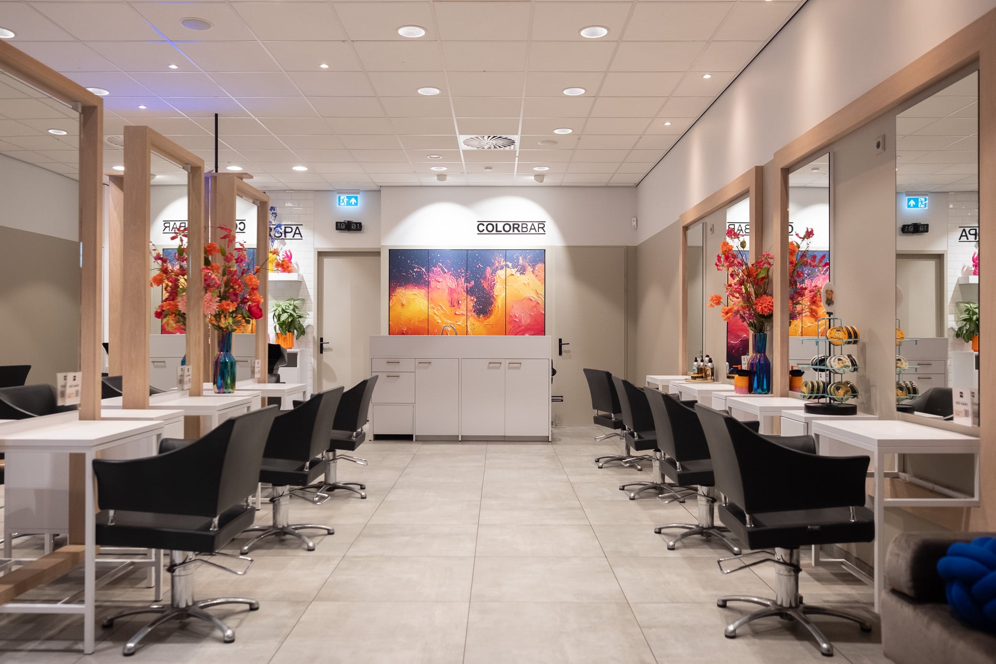 Modern kapsaloninterieur met zwarte stoelen en Colorbar branding, spiegel en professionele inrichting