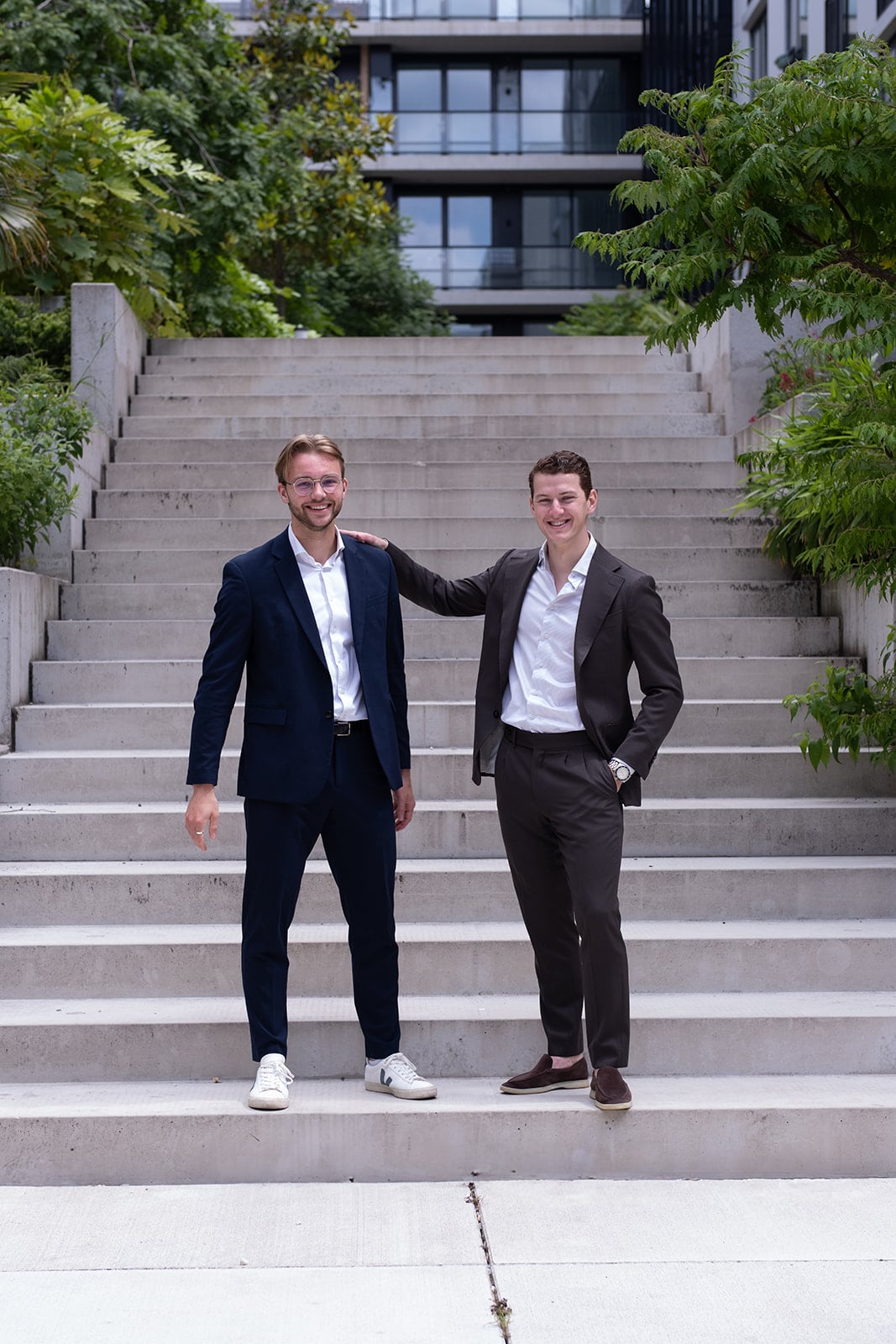 Twee mannen pakken arm om schouder betonnen trap teamfoto bedrijfsfotograaf Utrecht Jeffrey Roos