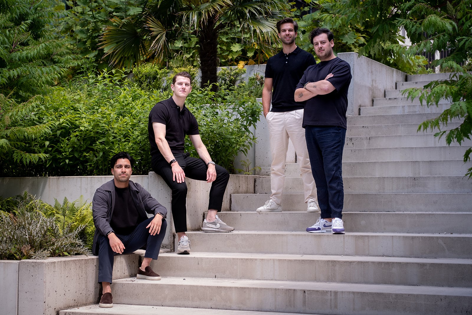Vier mannen betonnen trap groen landschap teamportret zakelijke fotografie digitaal marketingbureau